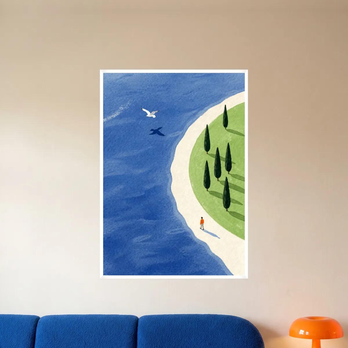 The seagull and coastline print in a white frame above a blue sofa