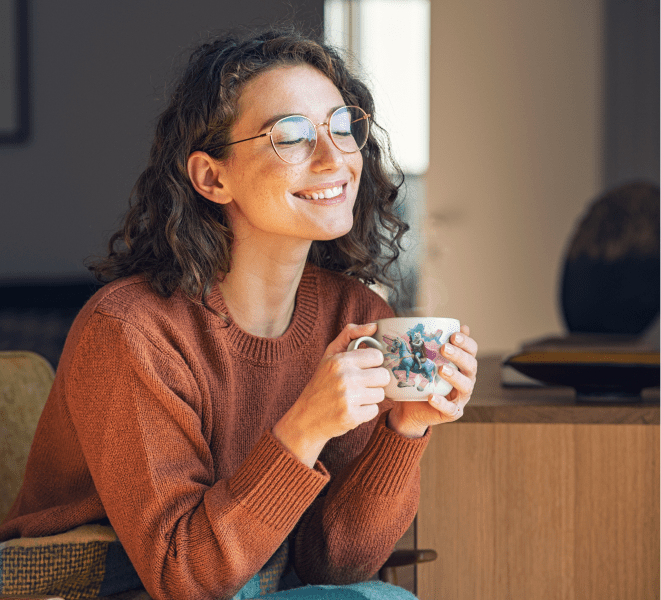 A contented woman with a gentle smile, enjoying a chill moment with her favorite mug featuring AI-generated graphics. The mug adorned with unique, artificially generated artwork serves as the perfect companion during moments of relaxation. The blend of happiness and cutting-edge technology makes this chillout moment even more special